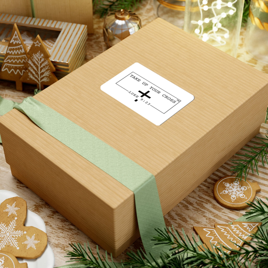 Wooden gift box with a green ribbon and a card on a festive background with cookies and lights.